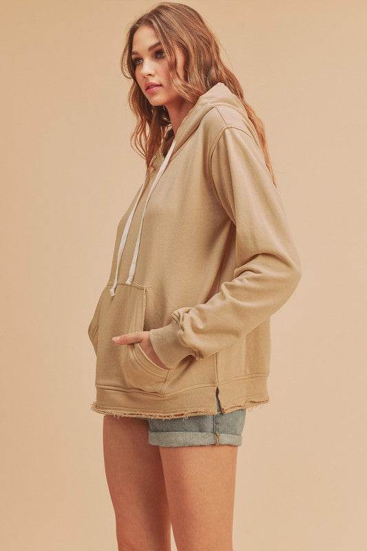 Aemi + Co Raw Hem Kangaroo Pocketed Drawstring Hoodie in Oatmeal - us.meeeshop