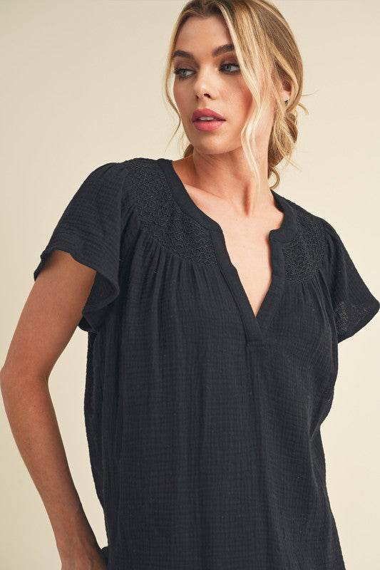 Aemi + Co Embroidered Trim Side Slit Notched Short Sleeve Blouse in Black in Black - us.meeeshop