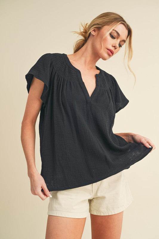 Aemi + Co Embroidered Trim Side Slit Notched Short Sleeve Blouse in Black in Black - us.meeeshop