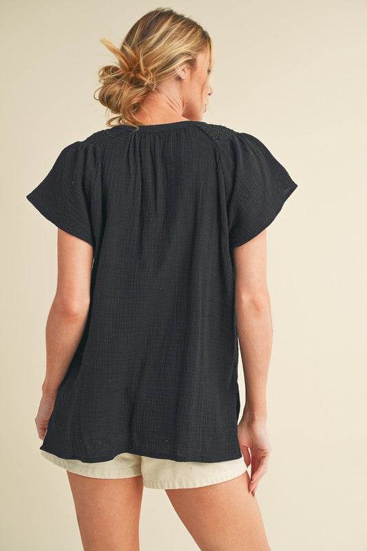 Aemi + Co Embroidered Trim Side Slit Notched Short Sleeve Blouse in Black in Black - us.meeeshop