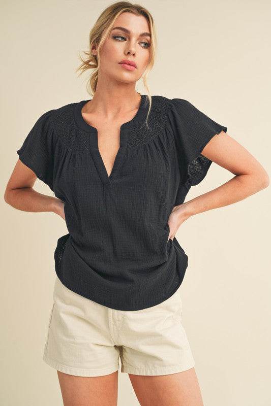 Aemi + Co Embroidered Trim Side Slit Notched Short Sleeve Blouse in Black in Black - us.meeeshop